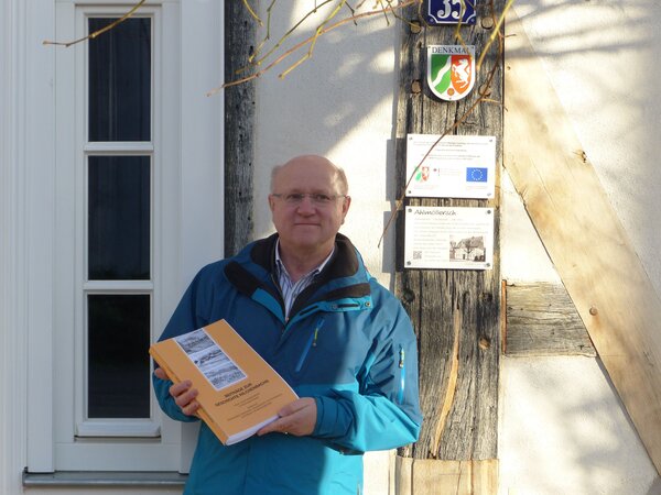 Reinhard Gämlich präsentiert das Manuskript seines neuen Buches vor dem Haus »Ahlmöllersch« in Müsen, das eines von 510 beschriebenen Gebäuden ist.