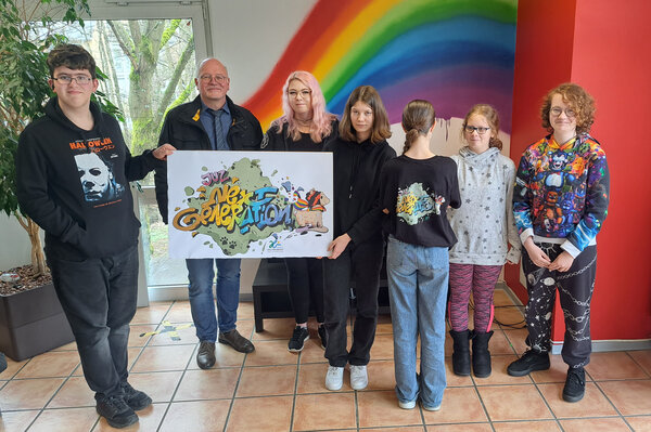 Die Jugendlichen haben das neue Logo ihres Jugendzentrums selbst entworfen. Jana Dulheuer (3. v. l.) und Christoph Ermert (2. v. l.) sind von dem Ergebnis begeistert. Sogar T-Shirts wurden schon mit dem Logo bedruckt.