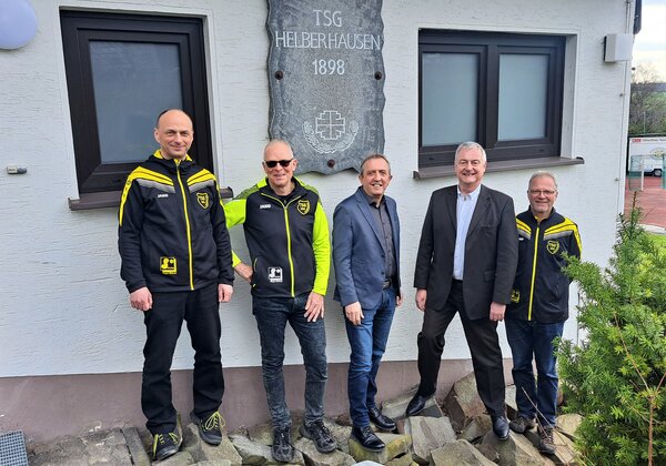 Peter Horn (l.), Meinhard Menn (2. v. l.) und Andreas Roth (r.) sind gl&uuml;cklich &uuml;ber die neuen Fenster und die neue Nebent&uuml;r der Turnhalle in Helberhausen. B&uuml;rgermeister Kyrillos Kaioglidis (M.) und Lutz He&szlig;elmann von der Sparkasse &uuml;berzeugen sich vor Ort davon, dass das Geld gut angelegt ist.