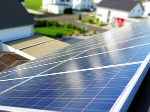 Bild vergr&ouml;&szlig;ern: Die Stadt Hilchenbach schafft finanzielle Anreize f&uuml;r den Klimaschutz. So f&ouml;rdert sie beispielsweise Photovoltaik- und Solaranlagen. Das Foto zeigt eine Solaranlage auf dem Dach eines Hauses. Im Hintergrund sind andere H&auml;user des Wohngebiets zu sehen.