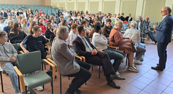 Landtagspr&auml;sident Andr&eacute; Kuper (r.) beantwortet die Fragen der Sch&uuml;lerinnen und Sch&uuml;ler des Gymnasiums Stift Keppel. Unter anderem werden die Arbeit im Landtag und der Klimaschutz thematisiert. B&uuml;rgermeister Kyrillos Kaioglidis und K&auml;mmerer Christoph Ermert (3. u. 2. v. r.) h&ouml;ren interessiert zu.