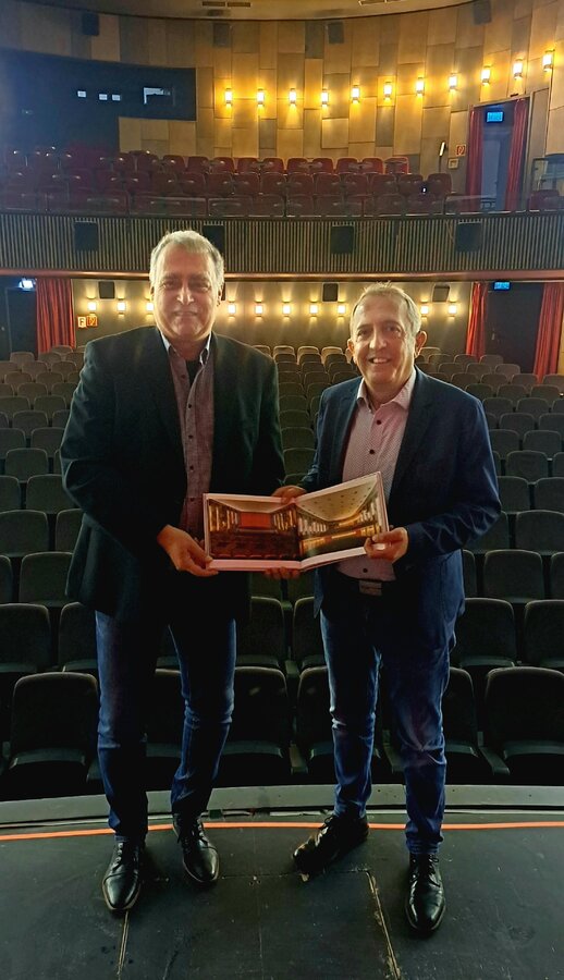 B&uuml;rgermeister Kyrillos Kaioglidis (links) und Jochen Manderbach halten den Bildband &raquo;Cinema Provinziale&laquo; in den H&auml;nden, in dem auch das Viktoria Filmtheater vorgestellt wird. 