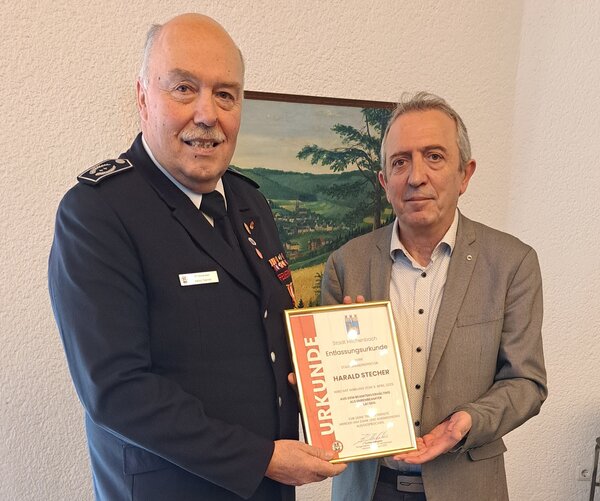 Harald Stecher erh&auml;lt von B&uuml;rgermeister Kyrillos Kaioglidis (von links) die Entlassungsurkunde.