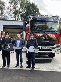 Bild vergr��ern: Schl�ssel�bergabe f�r Feuerwehrger�tehaus und Fahrzeug mit Karsten Lewitz, Kyrillos Kaioglidis und Timo Neuhaus (von links)