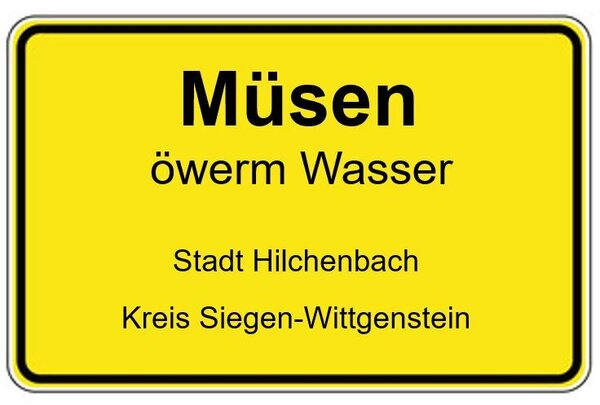 Müsen-Ortsschild mit dem Zusatz öwerm Wasser 