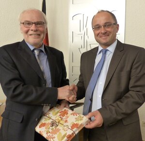 Bild vergr&ouml;&szlig;ern: Klaus St&ouml;tzel gratuliert B&uuml;rgermeister Holger Menzel nach der Amtseinf&uuml;hrung und &uuml;berreicht ein Geschenk.